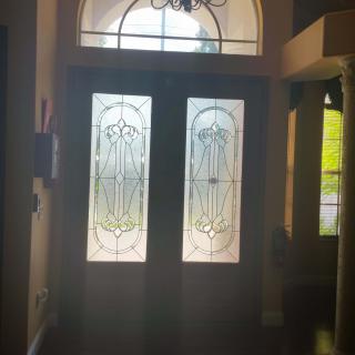 A decorative glass-paneled entrance door with intricate designs.
