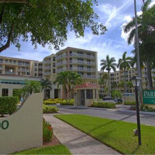 Entrance to a residential apartment complex with palm trees.
