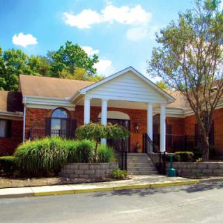 A charming residential building with a well-maintained front yard and a beautiful sky.