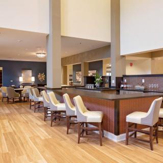 A modern hotel lobby featuring a bar area with stylish seating.