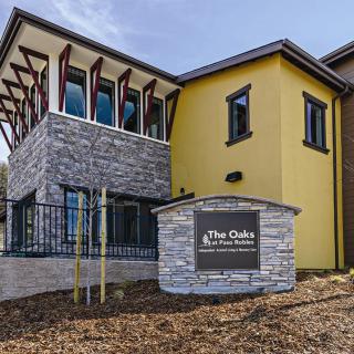 A modern clubhouse building with a stone facade and yellow accents.