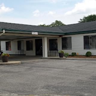 A view of a single-story commercial building with a parking area.