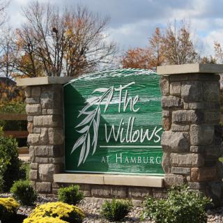 Entrance sign for The Willows at Hamburg surrounded by autumn foliage.