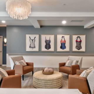 A modern living room with stylish seating and unique artwork on the wall.