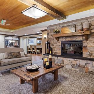 A cozy living room featuring a stone fireplace and modern wooden accents.