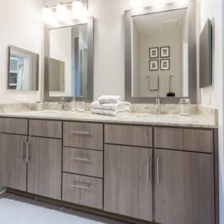 A modern bathroom with a double vanity, large mirrors, and contemporary lighting.
