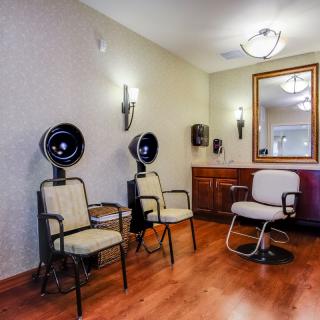 An inviting hair salon interior featuring styling chairs, hair dryers, and a large mirror.