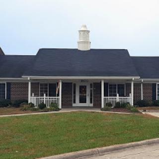 A charming residential house with a well-maintained lawn and a welcoming front porch.