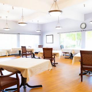 A spacious and well-lit dining area with elegant furniture, ready for guests.