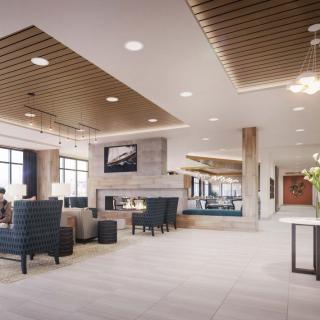 A modern lobby with comfortable seating, a fireplace, and ample natural light.