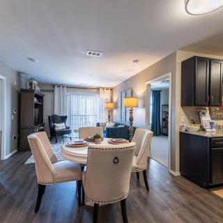 A modern open floor plan featuring a dining and living area with stylish furniture and wood flooring.