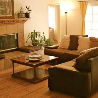 A cozy living room with a sectional sofa, coffee table, and fireplace.