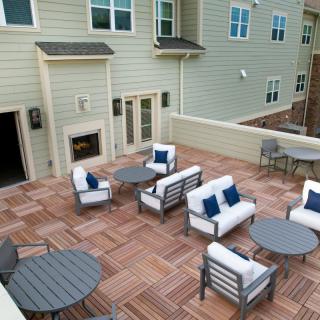 An inviting outdoor patio with modern furniture and a wooden deck.