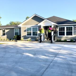 A modern single-story house with a large driveway and well-maintained landscaping.