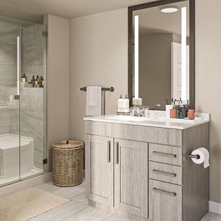 A modern bathroom featuring a sleek vanity and an illuminated mirror, with a glass-enclosed shower on the side.