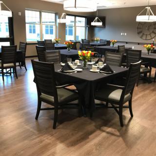 A well-arranged dining room with elegantly set tables and chairs.