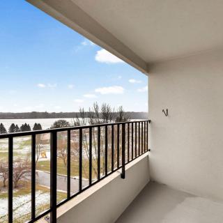 A spacious balcony overlooking a scenic view with clear skies and nature.