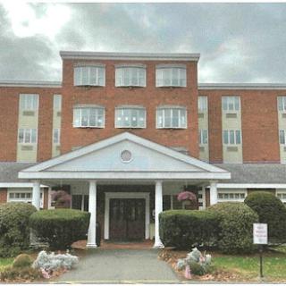 A classic brick building with an inviting entrance and landscaped front garden.