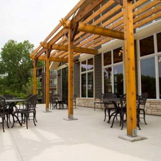 Outdoor dining area featuring a wooden pergola and stylish seating.