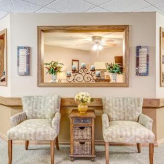 A cozy waiting area with two chairs and a table adorned with flowers.