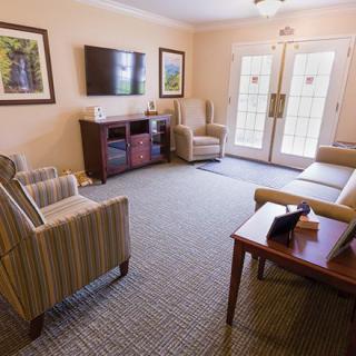 A cozy living room with comfortable seating and a television mounted on the wall.