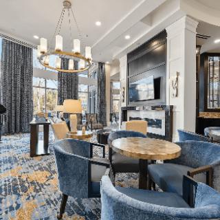 A luxurious lounge with modern seating and a stylish chandelier.