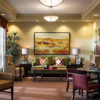 A cozy living room with a sofa, artwork, and warm lighting.