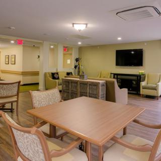 A modern living room featuring warm lighting, comfortable seating, and a flat-screen television.