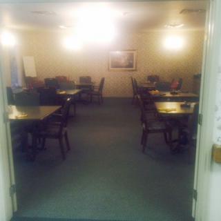 An empty conference room with tables and chairs arranged in rows.