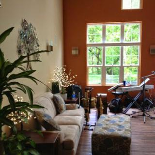 A cozy living room featuring comfortable seating, decorative plants, and a view of the outdoors.
