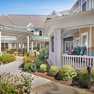 A charming building with a beautifully landscaped garden and inviting porch.