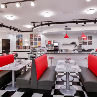 A retro-style diner with red booth seating and a classic black-and-white checkered floor.