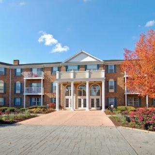 A residential building surrounded by autumn trees under a clear blue sky.