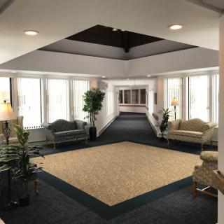 A spacious and well-lit lobby area featuring comfortable seating and plants.