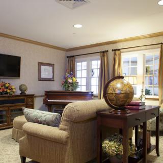 A cozy living room with elegant furnishings including a sofa, globe, and a television.