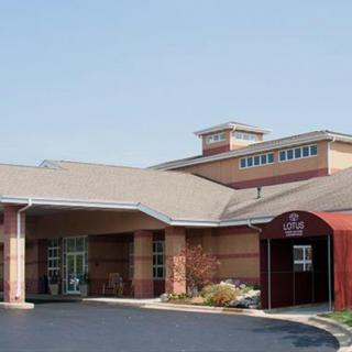 The entrance of a hotel with a covered driveway and red awning.