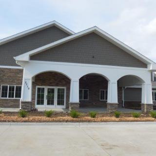 A commercial building with a prominent arched entrance and landscaped front area.
