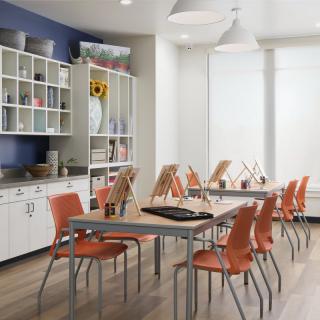 A modern classroom setup with tables and chairs arranged for art activities.