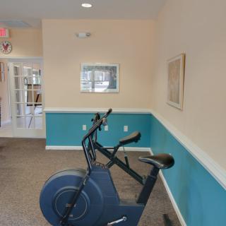 An indoor gym space featuring an exercise bike against a two-tone wall.