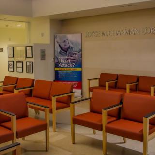 A quiet waiting room with rows of empty chairs and a promotional banner on the wall.