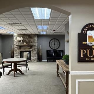 A cozy pub lounge area with a stone fireplace and round table.