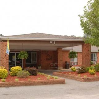 A building entrance with brick exterior and landscaped surroundings.