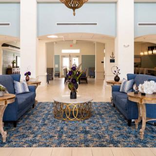 A well-decorated lobby with sofas, a central table, and an ornate rug.