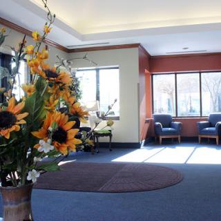 A bright and welcoming lobby featuring vibrant sunflowers, comfortable seating, and ample natural light.