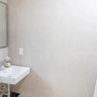 A minimalist bathroom with a modern sink and mirror.