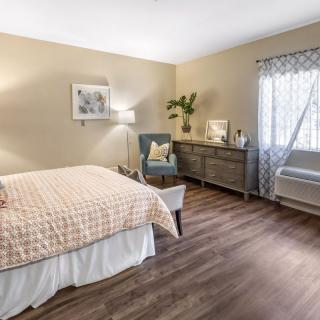 A cozy and modern bedroom with stylish furniture and wood flooring.
