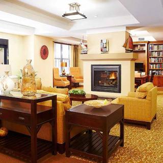A cozy living room with a fireplace, comfortable seating, and a bookshelf.