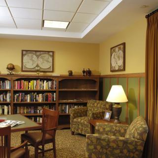 A cozy library corner with a seating area and bookshelves.