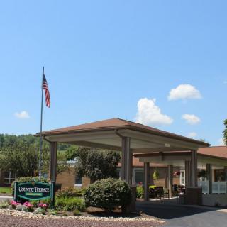 Entrance of a hotel with a prominent flagpole and landscaped surroundings.
