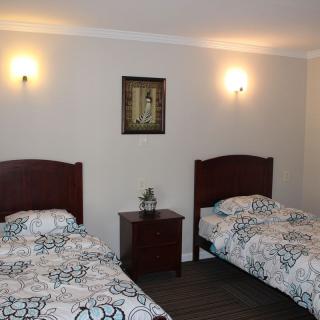 A cozy bedroom with two twin beds and soft lighting.